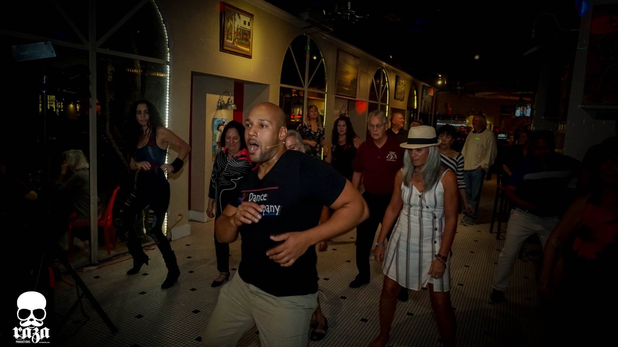 Dario and a room full of students dancing together