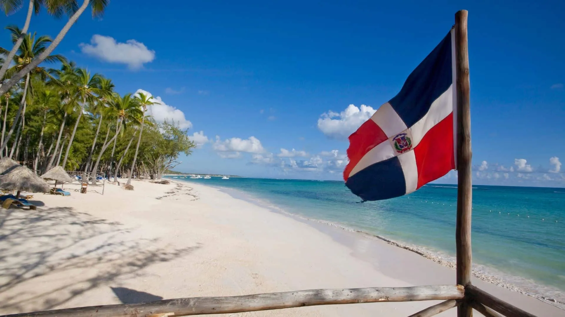 The Dominican flag flying on a tropical beach in the Dominican Republic
